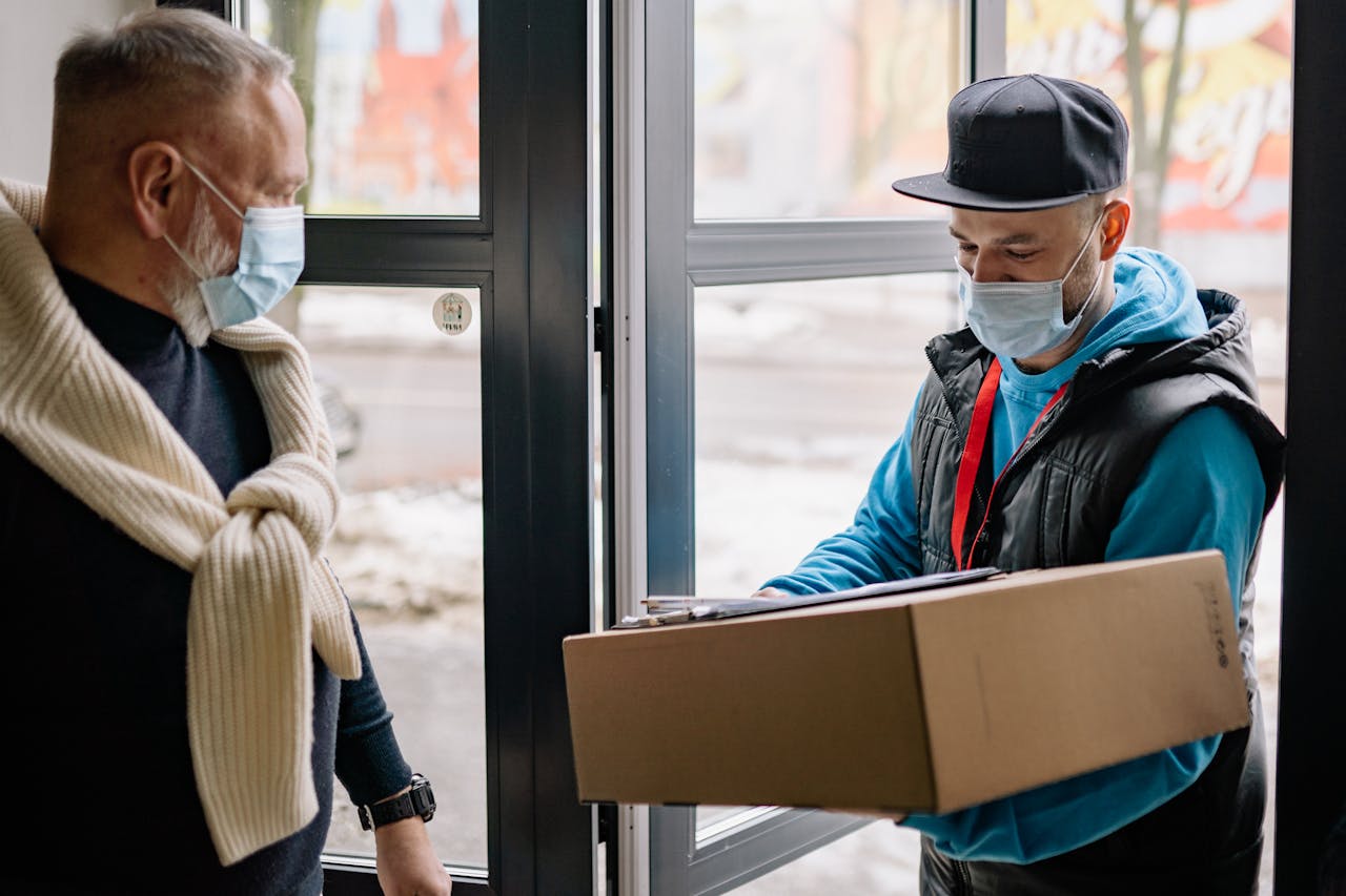 Masked delivery service during pandemic, showcasing contact-free parcel handover.